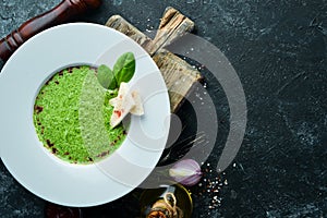 Spinach puree soup in a plate. Top view.