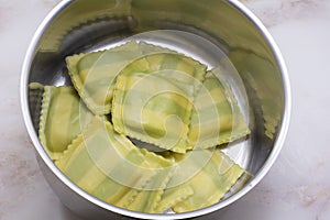 Spinach ravioli in stainless steel pan