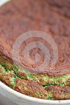 Spinach souflÃ© in ramekin with patterned napkin