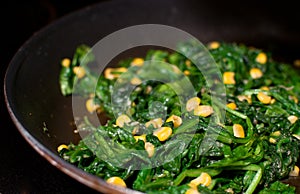 Spinach wilted and fried corn on skillet photo