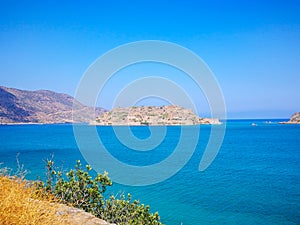 Spinalonga island with blue sky and transparent sea. Elounda, Spinalonga, Crete, Greece. Traveling at Crete, summer vacations and