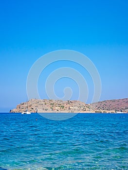 Spinalonga island with blue sky and transparent sea. Elounda, Spinalonga, Crete, Greece. Traveling at Crete, summer vacations and