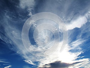 Spindrift clouds on blue sky before sunset photo