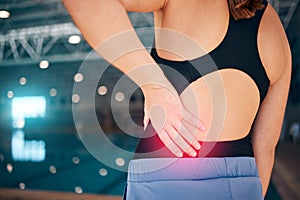 Spine pain, swimmer and woman by a pool with injury from exercise, workout and swim race. Back inflammation, muscle and