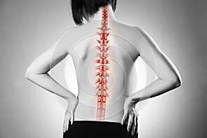 Spine pain, woman with backache and ache in the neck, black and white photo with red backbone