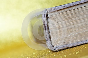 The spine of a thick old book lying on a yellow golden background. Library archive. History and memoirs. Literature and philology photo