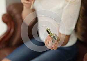 Spinner concept. little girl playing with green spinner at home - showing to camera