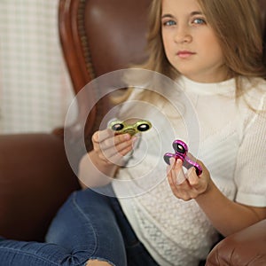 Spinner concept. little girl playing with two spinners green and pink