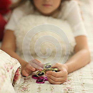 Spinner concept. little girl playing with two spinners green and pink