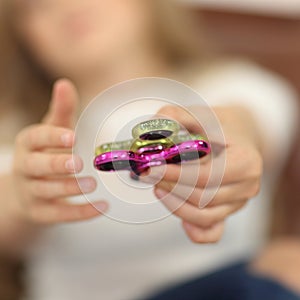 Spinner concept. two spinners green and pink in child`s hands closeup.