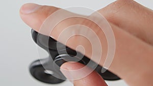 Spinner or fidgeting hand toy rotating on man`s hand