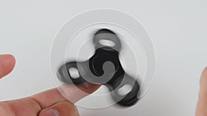 Spinner or fidgeting hand toy rotating on man`s hand