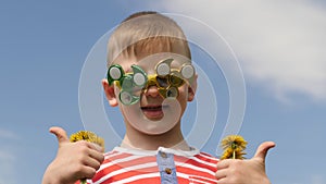 Spinner on the glasses is spinning. Fun on the street. Baby boy against the blue sky.