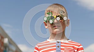 Spinner on the glasses is spinning. Fun on the street. Baby boy against the blue sky.