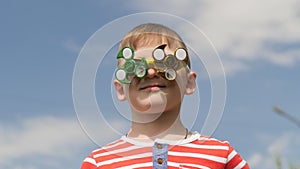 Spinner on the glasses is spinning. Fun on the street. Baby boy against the blue sky.