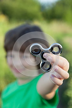 Spinner in the hand of a child smiling in the nature on a summer