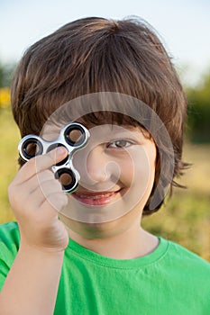 Spinner in the hand of a child smiling in the nature on a summer