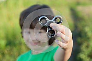 Spinner in the hand of a child smiling in the nature on a summer