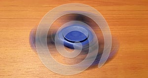 Spinner isolated on wood background. Blue toy spinner. Hand spinner isolated on wooden background. Toy spiner, spinner.