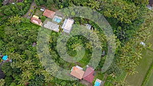 spinning aerial shot of secluded houses in dense jungle