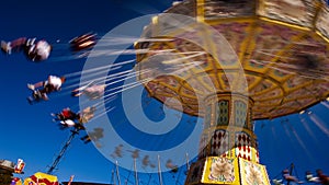 Spinning Carousel with people blurred against blue sky