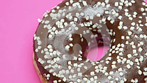 Spinning chocolate donut on pink background, temptation during diet, junk food
