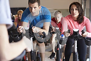 Spinning class on exercise bikes at a gym, close up