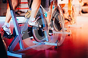 Spinning class, group activity on stationary bike. Team cardio excercise on bicycle.