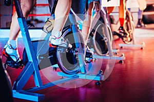 Spinning class, group activity on stationary bike. Team cardio excercise on bicycle. photo