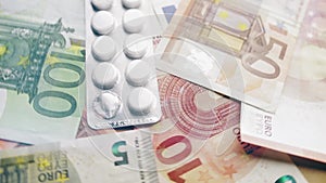 Spinning Euro banknotes and medicines. COVID-19 pandemia, economic crisis, default, healthcare or business concept.