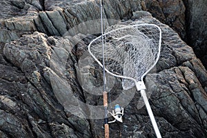 Spinning and landing net on a rocky sea