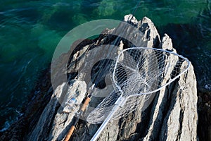 Spinning and landing net on a rocky shore