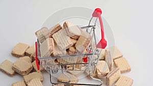 Spinning pile of square wafer biscuits and shopping cart