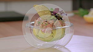 On spinning plate in bowl served portion of salmon tartar, closeup slow motion view