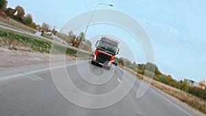 Spinning point of view: Semi truck is driving on suburban multi-lane road.