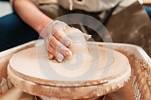 Spinning potters wheel with clay and hand