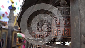 Spinning religious prayer wheels with written mantra Om Mani Padme Hum. Kathmandu, Nepal.
