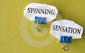 SPINNING SENSATION - the words is printed on a white piece of paper on a yellow background