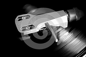 Spinning a vinyl record at the turntable in a very close up at the metallic Headshell