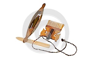 Spinning wheel and comb from vintage wool, isolated on a white background. Reconstruction of the events of the Middle Ages in