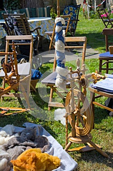 Spinning wheel and equipment on the open air. Yarn, wool, thread.