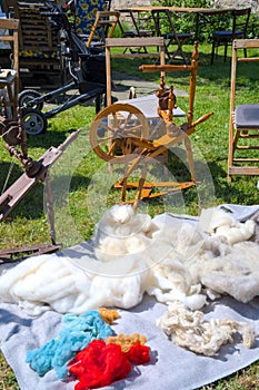 Spinning wheel and equipment on the open air. Yarn, wool, thread.