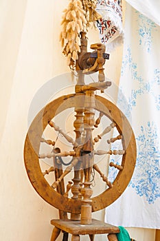 A spinning wheel with yarn baskets and old chair