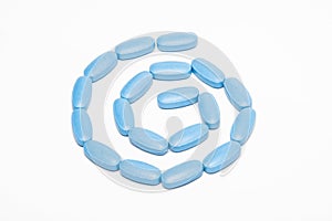 Spiral of blue pills isolated on white background