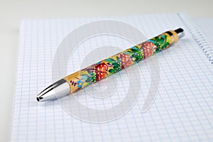 Spiral-bound notebook with a pen resting on top.