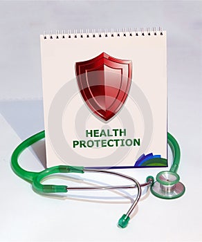 A spiral-bound notebook showcases a bold, red gleaming shield paired with a sleek stethoscope beneath it. photo