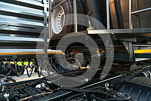 Spiral cable connecting truck cabin and trailer. Pneumatic hoses and electric cables on the coupler of the hitch between a tractor