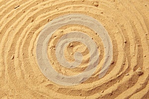 Spiral drawing on beach sand background.