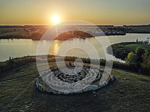 Spiral labyrinth made of stones, on sunset lake