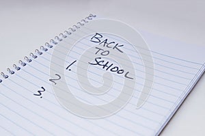 A spiral lined notebook with `Back to School` and 1.2.3 written on it